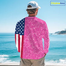 Load image into Gallery viewer, Person wearing a long-sleeve shirt with American flag and pink abstract design by the ocean.