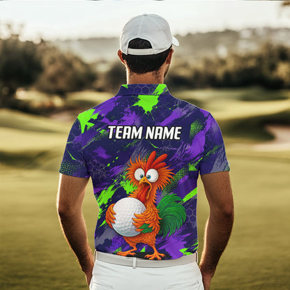 A man standing on a golf course seen from behind, wearing a short-sleeve polo shirt with a purple and green paint-splatter design, a cartoon rooster holding a golf ball, and the text 'TEAM NAME' on the back. He is also wearing a white cap and white pants.
