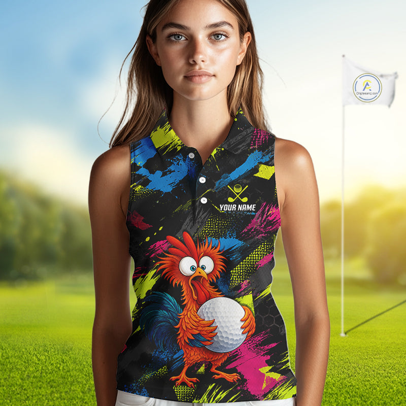 A woman modeling a sleeveless collared golf shirt with a colorful abstract print and a cartoon rooster holding a golf ball. The shirt has a black base with blue, pink, yellow, and green paint splatter patterns, and a small white text placeholder reading 'YOUR NAME'.