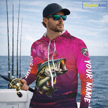 Load image into Gallery viewer, Man wearing a pink fishing-themed hoodie with a large fish graphic, standing on a boat with ocean and sky in the background.