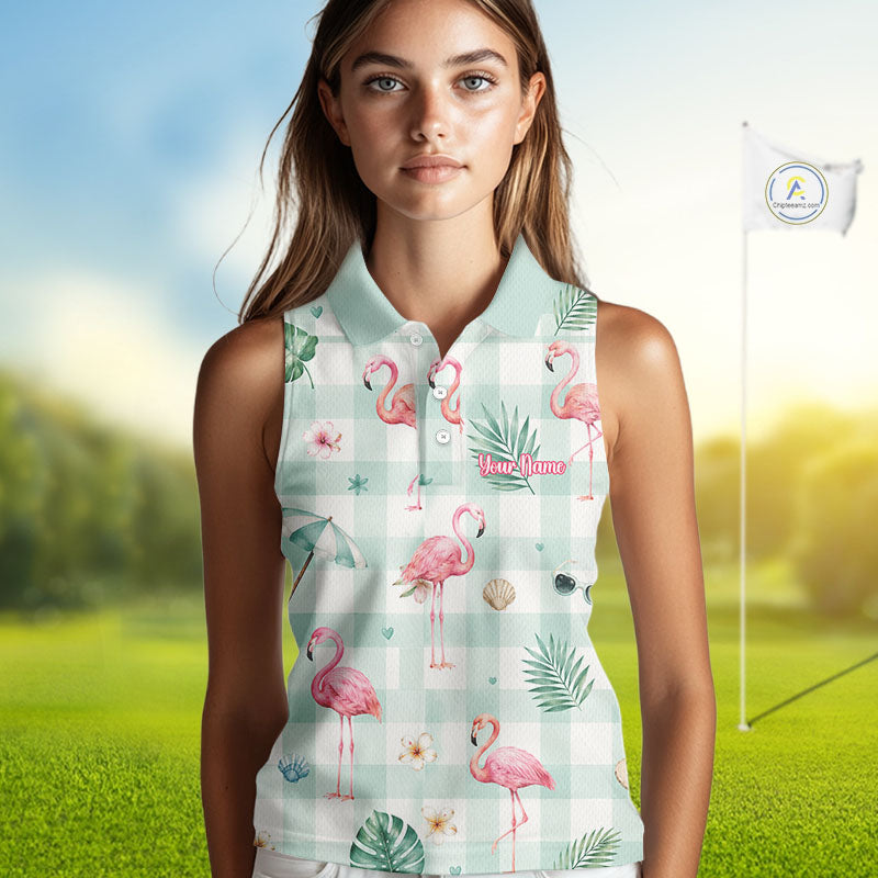 A woman modeling a sleeveless polo shirt with a pink flamingo and tropical leaf print over a pale green gingham background, set against a blurred golf course background with a flagstick visible.