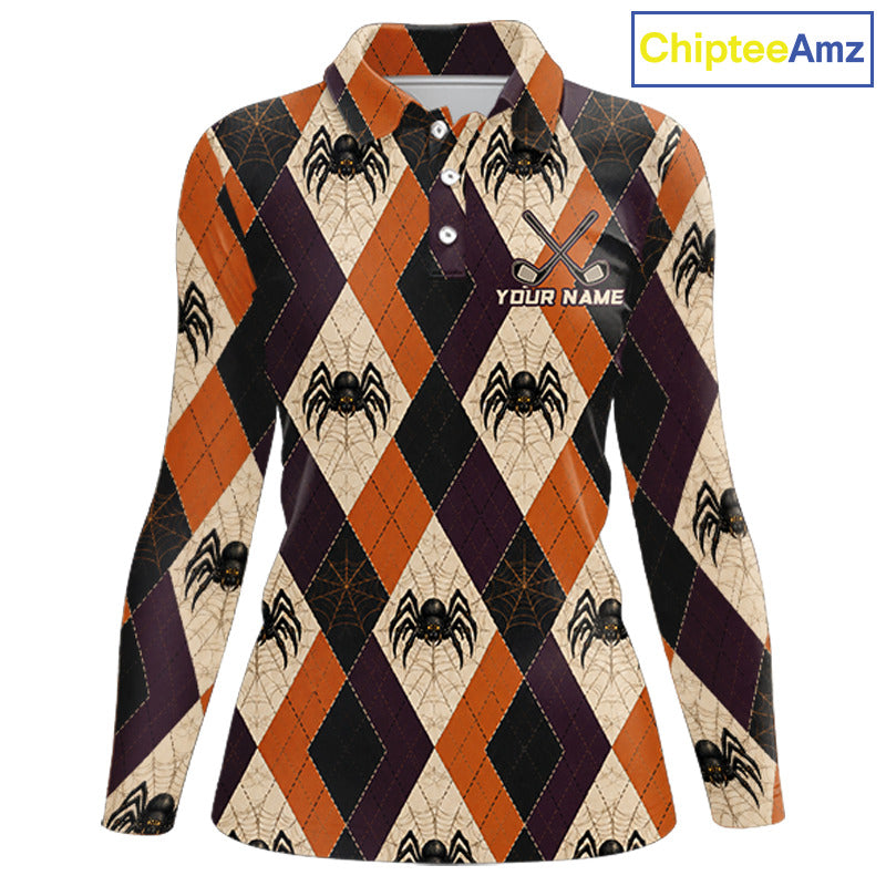 A women's long-sleeve collared polo shirt with a Halloween-themed argyle pattern featuring orange, black, and beige diamonds with spider and spiderweb motifs. The shirt has a custom name print area on the left chest with crossed scissors graphic.