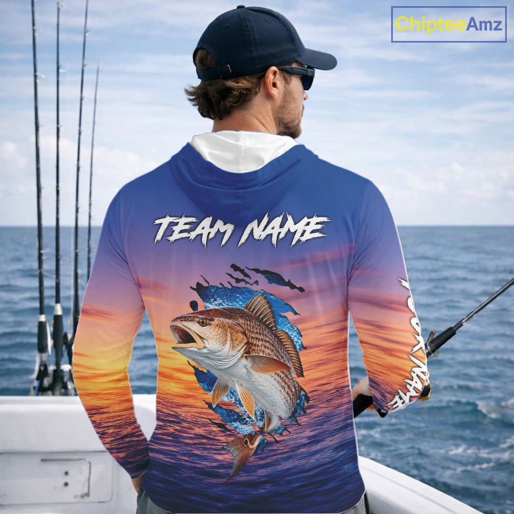 Angler wearing Redfish Fishing Sunset custom long sleeve hooded redfish offshore fishing shirt on the boat at sunset