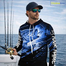 Load image into Gallery viewer, Man wearing a long sleeve hooded fishing shirt with a blue bass fish design on a boat