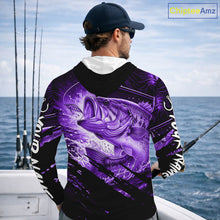 Load image into Gallery viewer, Person wearing a purple and black bass hooded fishing shirt with a fish design, standing by the ocean.
