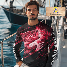 Load image into Gallery viewer, Man wearing a long sleeve fishing shirt with a red bass fish design on a boat