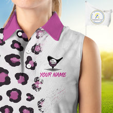 Load image into Gallery viewer, Woman wearing a sleeveless golf shirt with a leopard print and golf ball design, on a blurred golf course background.