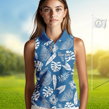 Load image into Gallery viewer, Woman wearing a blue sleeveless golf shirt with white leaf pattern on a golf course.