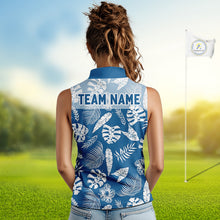 Load image into Gallery viewer, Woman wearing a blue sleeveless golf shirt with white leaf pattern on a golf course