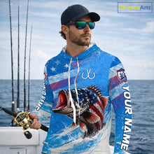 Load image into Gallery viewer, Man wearing a long sleeve hooded fishing shirt American flag design with custom name, standing on the boat.
