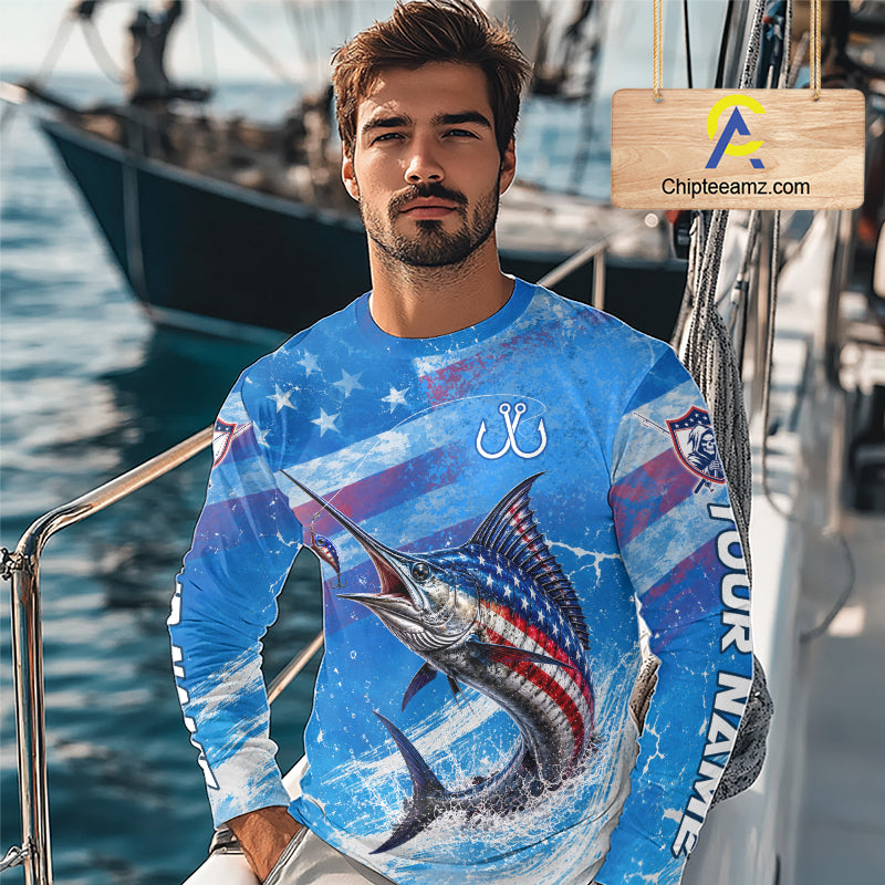 Man wearing a blue patriotic marlin fishing shirt long sleeve with custom name, standing on a boat