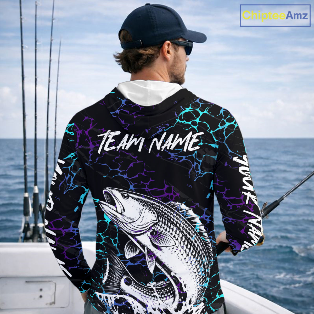 Angler wearing Redfish Fishing neon blue long sleeve hooded saltwater fishing shirt on the boat with custom team name on the back