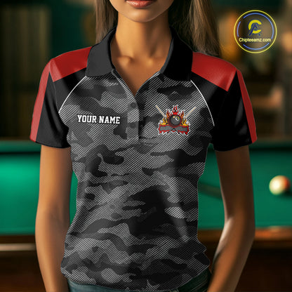 Woman wearing a red camouflage American flag 8 ball billiard jersey beside a pool table front view.