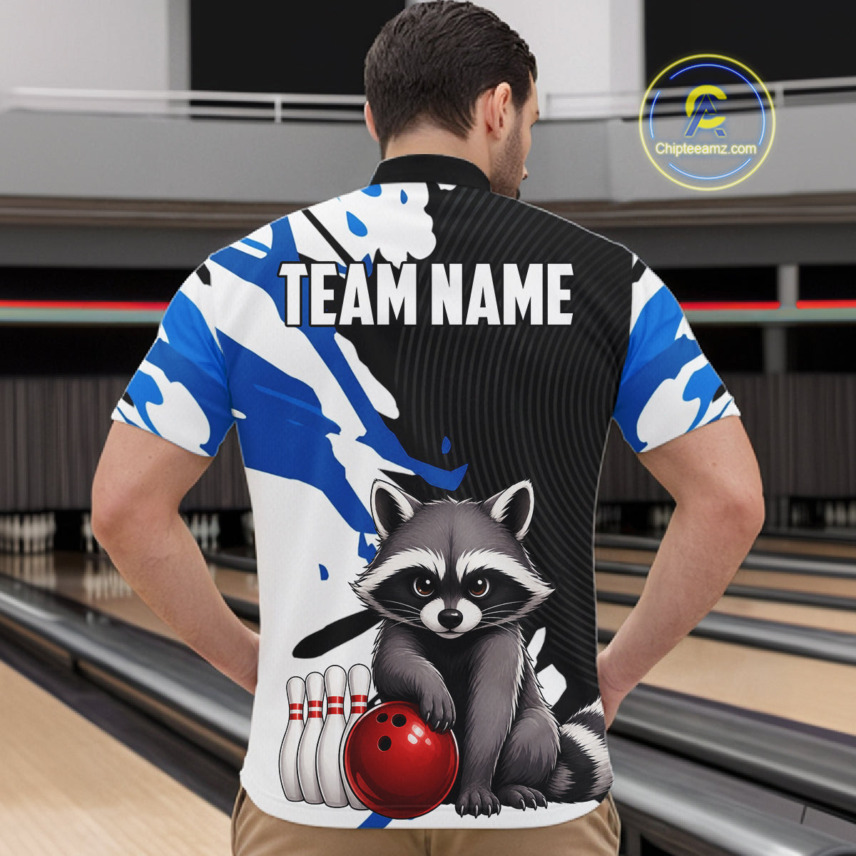 Person wearing a bowling-themed shirt with a raccoon graphic in a bowling alley.