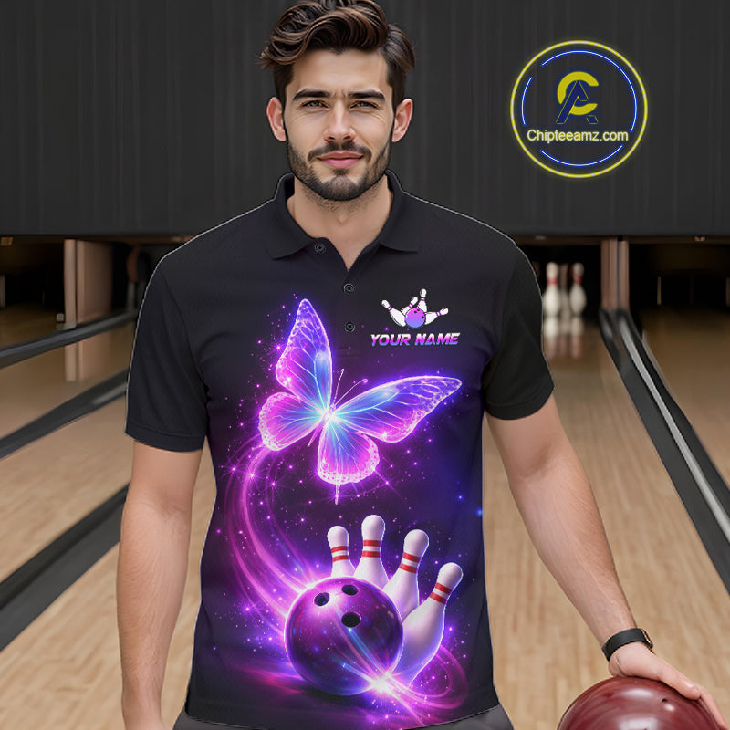 Man wearing a black bowling shirt with a colorful butterfly design in a bowling alley.
