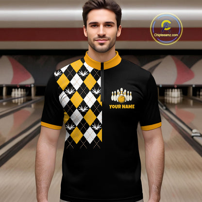 Man wearing a black and yellow bowling shirt with a pattern and logo in a bowling alley.